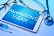 Parkinson's disease word on tablet screen with medical equipment on background