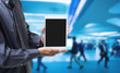 Businessman hands holding digital tablet computer with blurred crowd background