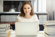 © WHstudio Leushin N - People and education. Attractive Caucasian woman teacher smiling at the camera, looking happy and cheerful, typing on keyboard of her laptop with copy space for your text or promotional content