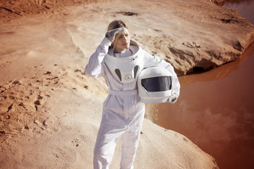 Wall Mural - futuristic astronaut without a helmet on another planet, image with the effect of toning