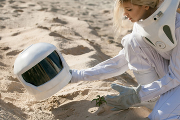 Wall Mural - grow plants on mars, futuristic astronaut without a helmet, another planet, image with the effect of