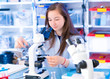 © luchschenF - Teen girl in school laboratory. University nature science lab. Researcher working with binocular microscope