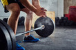 © baranq - Weightlifter clapping hands before workout with barbell at the g