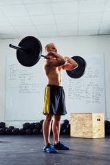 Wall Mural - Clean exercise - young athlete doing functional workout at the g