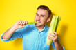 © Africa Studio - Handsome man eating celery on yellow background