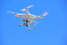 White Drone With Video Camera In Blue Sky