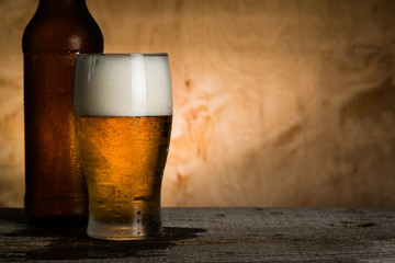 Canvas Print - Beer in bottle and glass with ice drops