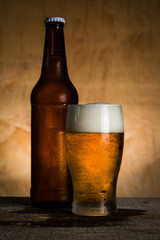 Canvas Print - Beer in bottle and glass with ice drops