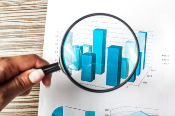 Magnifying glass and business growth graph