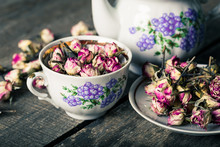 Vintage Teapot And Cup With Blooming Tea Flowers On Wooden Background
