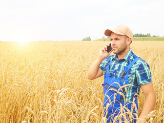 Farmer in a plaid shirt controlled his field. Talking on the pho