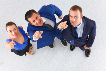 Business people standing together looking up and pointing at the camera- topview