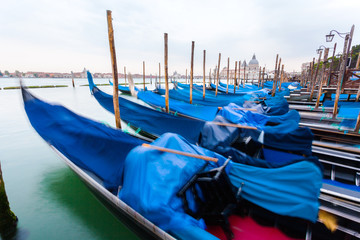 Pier gondolas near Piazza San Marco in Venice at sunrise. A number of boats on the background of the waterfront in Venice. Italy