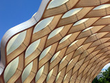Fototapeta Uliczki - Wooden honeycomb geometric pattern against blue sky