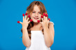 © Cookie Studio - Young pretty girl holding raspberry over blue background.