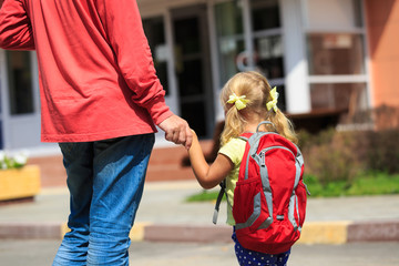 father walking little daughter to school or daycare