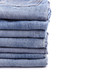 © SKT Studio - Stack of old blue jeans isolated on white