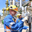 Industriearbeiter mit Schutzausrüstung in einer Raffinerie bedient Anlage // Industrial workers with protective equipment in a refinery operated facility