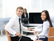 © ASDF - Happy business people looking at camera in office and  using com