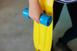 © kegfire - Closeup of a girl holding yellow longboard.