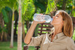 © plprod - femme dans un jardin qui boit de l'eau