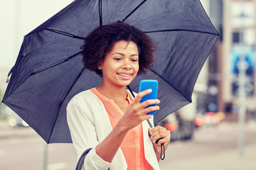 Wall Mural - businesswoman with umbrella texting on smartphone