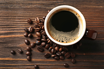 Canvas Print - Cup of coffee with beans on wooden table