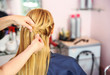 © Africa Studio - Hairdresser braiding woman's hair in hairdressing salon