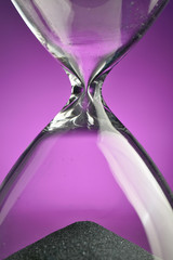 Wall Mural - Closeup hourglass on purpple background