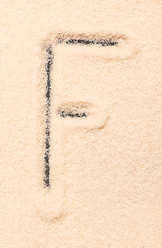 F letter written on sand