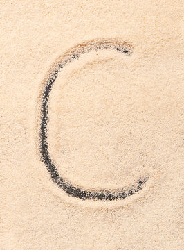 C letter written on sand