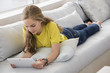 © onoky - Beautiful teenage girl using a digital tablet on sofa
