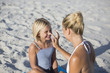 © onoky - Mother rubbing sunscreen on daughter's nose