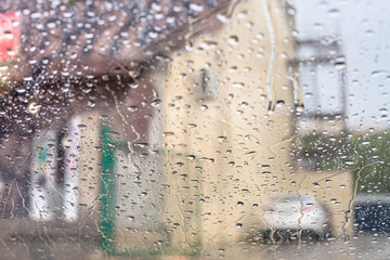 Poster - rain trickles on windscreen and blurred house