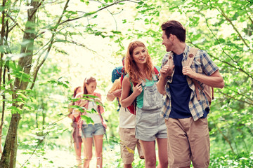 Canvas Print - group of smiling friends with backpacks hiking