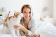 © Syda Productions - happy young woman with cat in bed at home