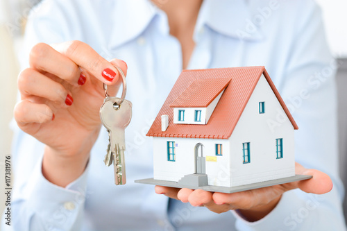 Plakat Agent nieruchomości przekazuje własność lub nowe klucze do domu klientowi