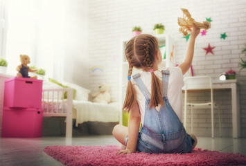 Wall Mural - girl playing with toy airplane