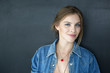 © ADDICTIVE STOCK - Smiling girl in denim jacket on grey background