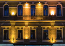 Several Windows In A Row And Balcony On Night Illuminated Facade Of Urban Office Building Front View, St. Petersburg, Russia.
