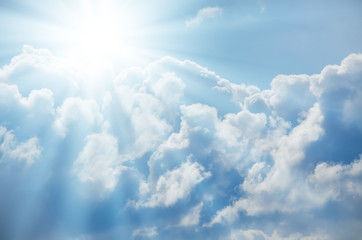 bright sun shines among the white clouds