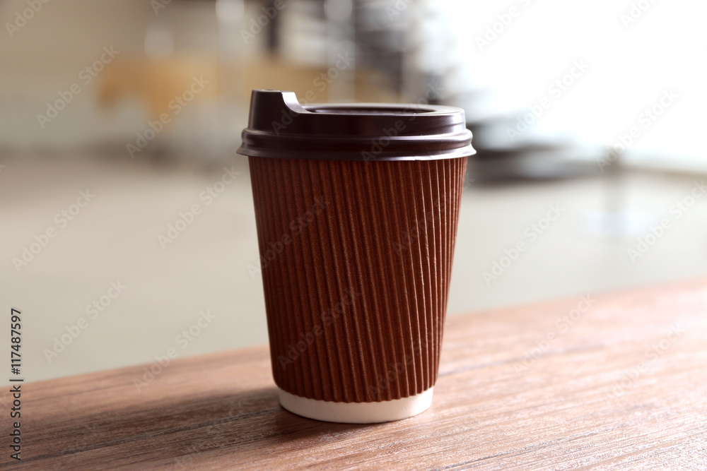 Paper cup of coffee on blurred background