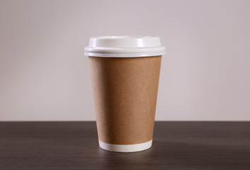 Wall Mural - Paper cup of coffee on light background