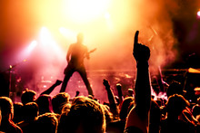 Silhouette Of Guitar Player In Action On Stage In Front Of Concert Crowd