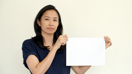 Wall Mural - South East Asian girl casually holding while sign for copy space