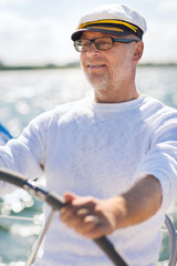 Poster - senior man at helm on boat or yacht sailing in sea