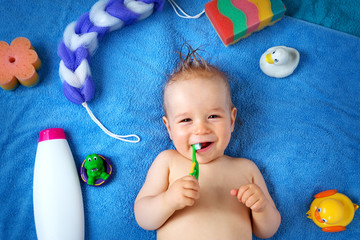 Baby lying on towel with washing tools