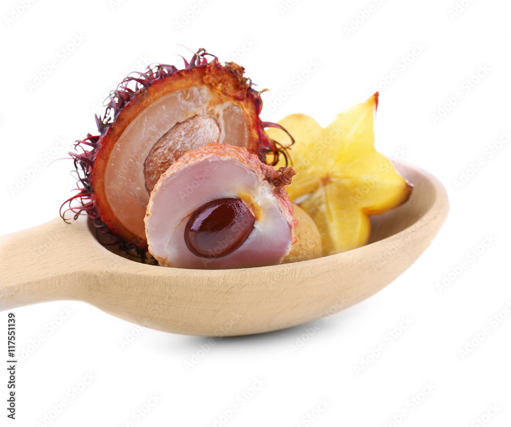 Exotic fruits in wooden spoon isolated on white
