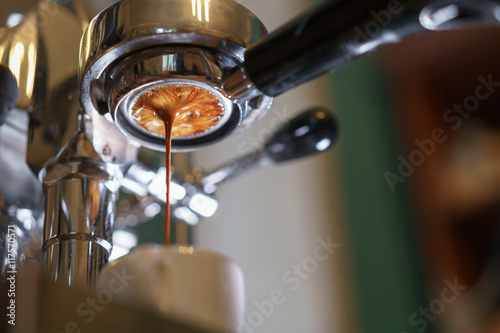 Fotografía espresso pouring from bottomless portafilter