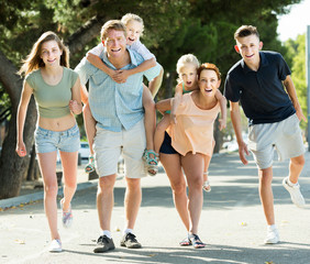 Parents with kids taking fast promenade in city